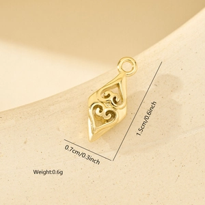 Macro di un ciondolo a rombo dorato da 1,5cm x 0,7cm con zirconi e motivi a cuore