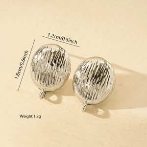 Macro detail of silver oval earrings showing irregular texture and dimensions 1.6x1.2cm
