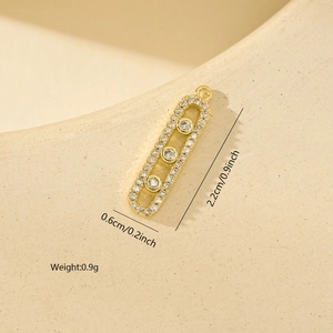 Dettaglio macro del ciondolo geometrico dorato con zirconi e dimensioni precise