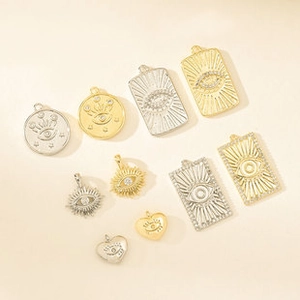 Macro shot of 18K gold and silver plated evil eye charms with cubic zirconia stones