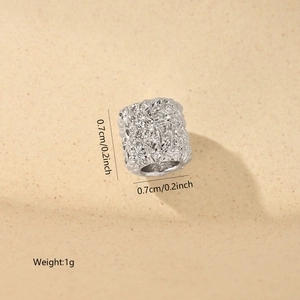 Macro shot of silver textured cylinder bead with 0.7cm dimensions and zircon inlay details