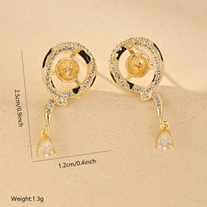 Macro shot of gold-plated snake earrings with white zircons and black enamel details