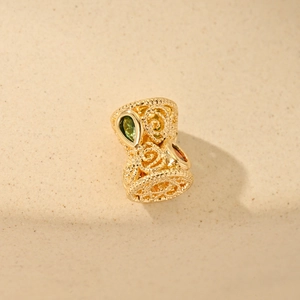 Detailed hollow geometric bead in gold plating with green and orange gemstones for DIY jewelry
