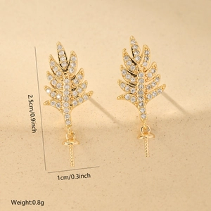Detailed view of leaf-shaped gold copper charms with zircon stones and size measurements
