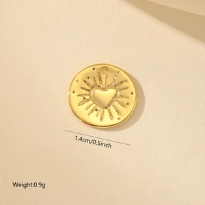Détail d'un pendentif rond doré de 1,4 cm avec relief cœur et rayons pour bijoux DIY