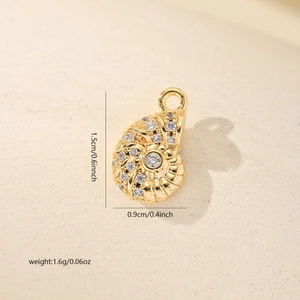 Detail view of gold conch pendant with cubic zirconia inlay showing 1.5cm x 0.9cm dimensions