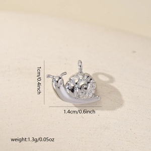 Macro detail of a 1.4cm silver snail pendant with white enamel for DIY jewelry making