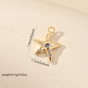 Macro shot of gold starfish pendant with blue gemstone and white zircon accents