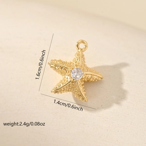 Macro shot of gold starfish pendant with cubic zirconia and size dimensions in inches