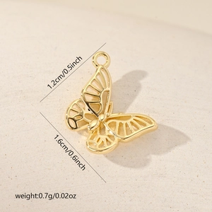 Macro detail of gold butterfly charm with 1.2cm by 1.6cm dimensions and 0.7g weight