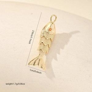 Détail macro du pendentif carpe koi dorée avec écailles et gemme orange sur l'œil