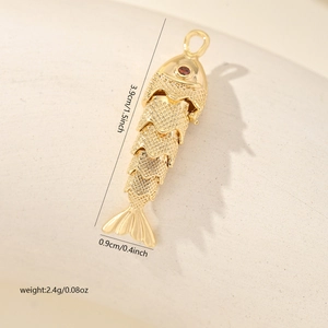 Détail du pendentif poisson doré avec œil rouge pour création de bijoux DIY