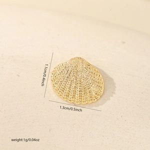 Detailed view of a gold shell charm showing fine textures and technical dimensions