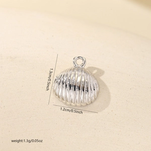 Macro view of shell-shaped silver-plated metal pendant showing 1.3cm x 1.2cm dimensions