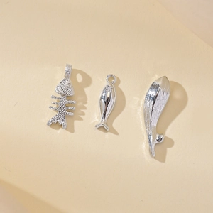 Polished silver ocean-themed fish bone and whale tail pendants set with small zircons