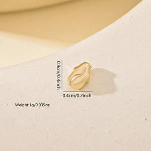 Macro detail of irregular gold metal bead showing 0.9cm height and reflective texture