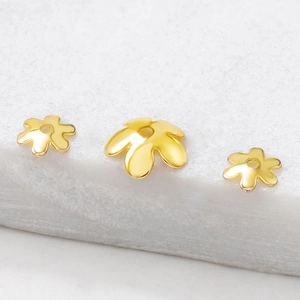 Goldene Blütenblätter Perlenkappen aus Metall für DIY Schmuckherstellung auf Marmor