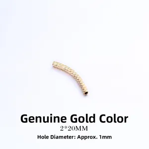 Macro shot of 2x20mm gold-plated curved tube beads with diamond-cut texture details