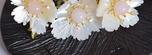 Detailed macro view of gold plated brass flower brooch with white shell petals and pink core