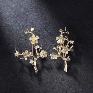 Detail of gold-plated plum blossom branch brooches with sparkling zircon flower centers