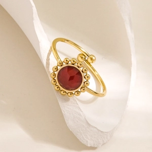 Golden stainless steel ring with red faceted gemstone and beaded milgrain edge detail