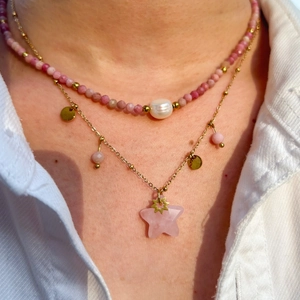 Macro detail of layered gold necklace with pink rhodochrosite beads and star pendant