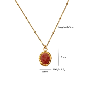 Detail of 14K gold plated necklace featuring a red oval stone pendant and bead chain