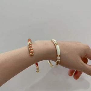 Brazalete C de esmalte estilo bambú en naranja y crema con acero de titanio chapado en oro
