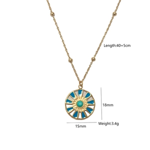Macro view of gold-plated compass pendant with turquoise stone and dimension labels