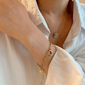 Elegant gold necklace and bracelet set with shell pendant and sparkling charm