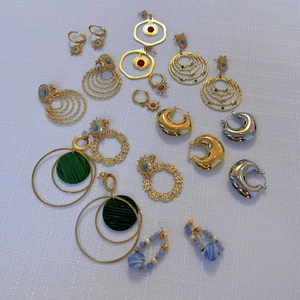 Assorted boho gold hoop earrings with marble stone and vintage floral charms on white fabric