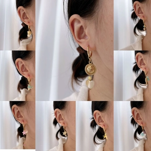 Elegant gold titanium hoop earrings set with ocean charms and natural stone pendants