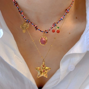 Layered colorful braided cord necklace with cactus and star pendants on a model