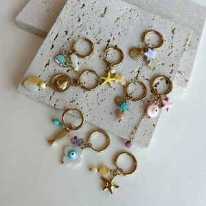 Marine themed hoop earrings with starfish and shell charms on beige stone plate