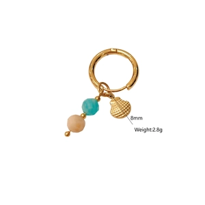 Detailed view of gold hoop earring with natural stone beads and 8mm conch shell charm