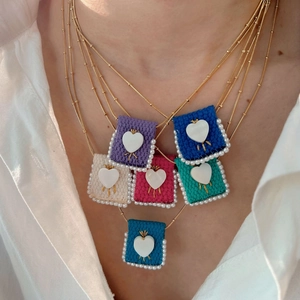 Colorful woven square necklace pendants with white heart and pearl details on gold bead chains