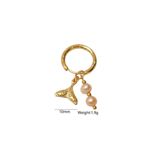 Détail de créoles dorées avec pendentif queue de poisson et perles en pierre rose