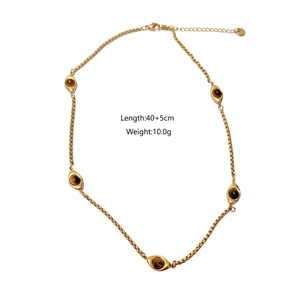 Vista de detalle del collar dorado con cinco amuletos de ojo y piedras ojo de tigre marrones