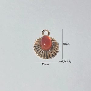 Detail view of gold sun pendant with red agate inlay including 18mm by 15mm dimensions