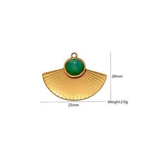 Detailed view of a fan-shaped gold pendant with a green gemstone and ribbed texture
