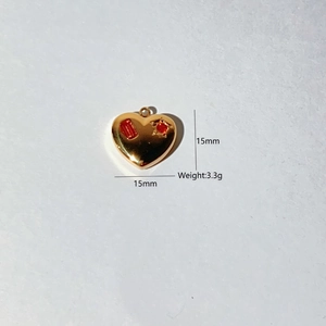 Detailed 15mm gold heart pendant with red stones and starburst engraving, weight 3.3g