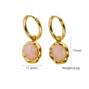 Détail de boucles d'oreilles dorées avec pierres naturelles roses et bords irréguliers
