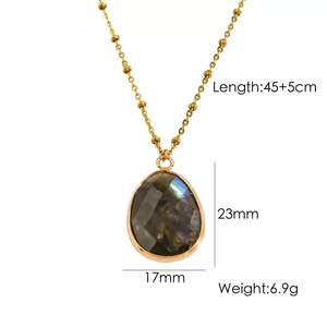 Detailed view of teardrop grey stone pendant with gold chain and size specifications