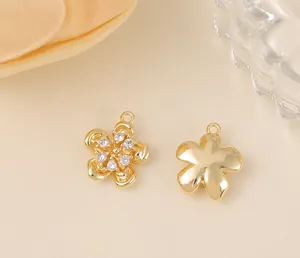 Vue macro de breloques fleurs dorées avec zircon et dimensions de 1,4 cm par 1,3 cm