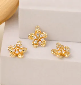 Gros plan détaillé de pendentifs fleurs dorées avec zircons cubiques sur un support en pierre