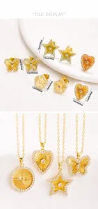 Detalle del conjunto de joyas doradas con motivos de estrella corazón mariposa y ave