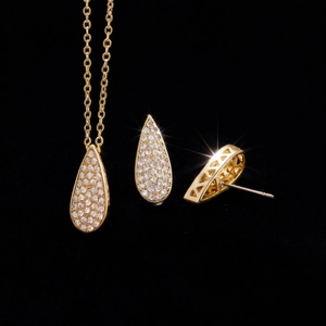 Detalle macro del conjunto de joyería en forma de gota con baño de oro y circonitas