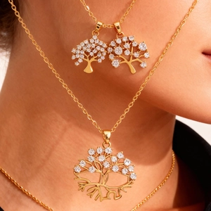 Detalle del colgante del árbol de la vida dorado y pendientes a juego con circonitas