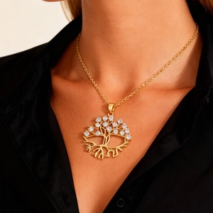 Detalle del colgante Árbol de la Vida dorado con circonitas blancas brillantes sobre modelo