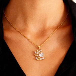 Primer plano detallado de un collar Árbol de la Vida dorado con piedras de circón